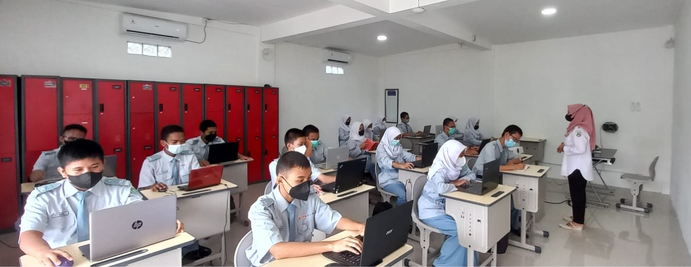 Siswa kelas Kubinar belajar dengan laptop di kelas berloker merah